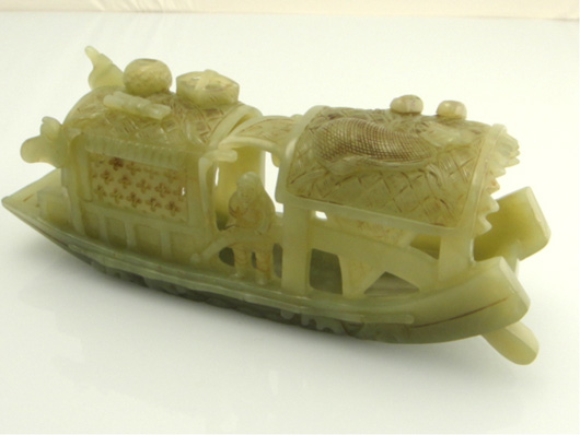 This 7-inch-long celadon jade model of a covered boat is openwork carved with three figures on board with accoutrements atop the roof. It is Lot 50 and expected to command around $2,000. Image courtesy of 888 Auctions.